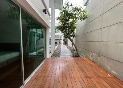 Outdoor walkway with wooden decking and adjacent modern home