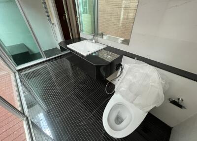 Modern bathroom with glass shower and black-tiled floor