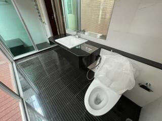 Modern bathroom with glass shower and black-tiled floor