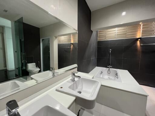 Modern bathroom with bathtub, sink, and toilet