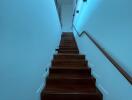 Staircase with wooden steps and white walls