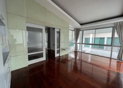 Spacious living room with large windows and wooden floor