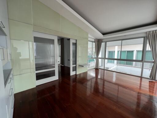 Spacious living room with large windows and wooden floor