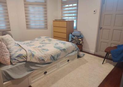 Cozy bedroom with bed, dresser, and chair