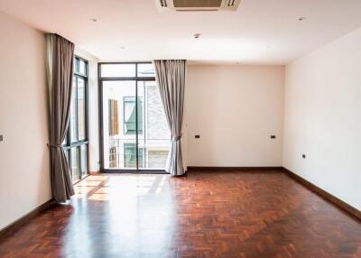 Spacious and well-lit living room with wooden flooring and large windows