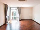 Spacious and well-lit living room with wooden flooring and large windows