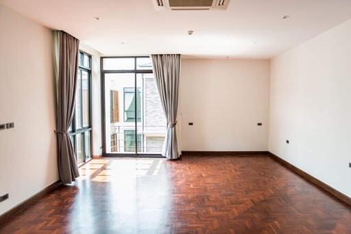 Spacious and well-lit living room with wooden flooring and large windows