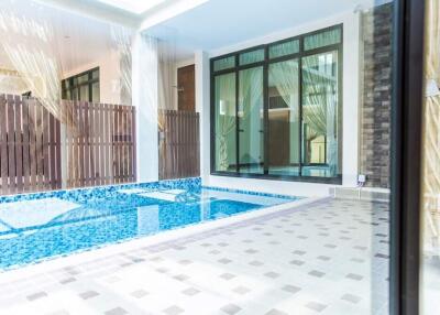 Indoor pool area with tiled flooring and large windows