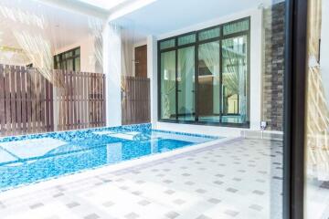 Indoor pool area with tiled flooring and large windows