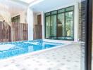 Indoor pool area with tiled flooring and large windows