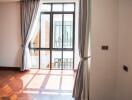 Sunlit living room with wooden floors and large window