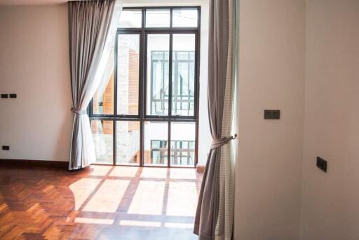 Sunlit living room with wooden floors and large window