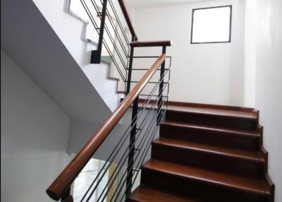 Interior staircase with wooden steps and metal railing