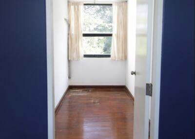 Minimalist bedroom with wooden flooring and large window