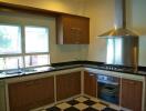 Modern kitchen with wooden cabinets, stainless steel appliances, and large window