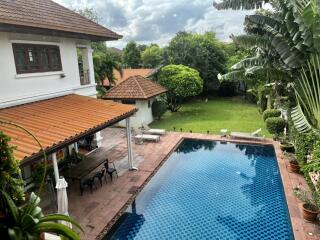 Outdoor view of backyard with pool and garden