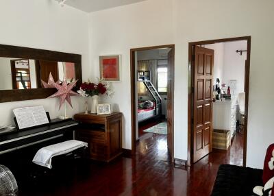 Living area with piano and view to bedroom