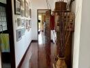 A decorated hallway with wooden flooring and picture frames on the wall.