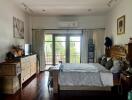 Spacious bedroom with large windows and balcony access