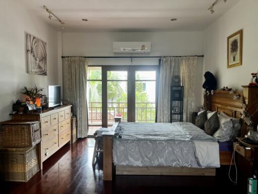 Spacious bedroom with large windows and balcony access