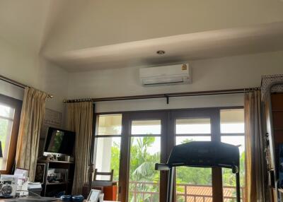 Main living area with a ceiling fan, air conditioning, and balcony access