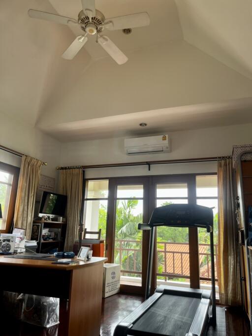 Main living area with a ceiling fan, air conditioning, and balcony access