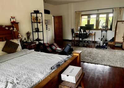 Spacious bedroom with bed, home gym, and workspace