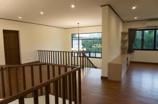 Spacious living area with wooden flooring and large windows