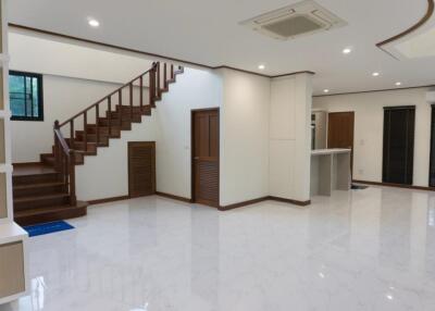 Spacious living room with staircase and open kitchen area