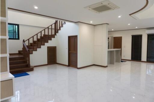 Spacious living room with staircase and open kitchen area