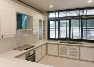 Modern kitchen with white cabinets and large windows