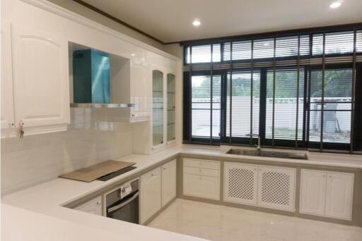 Modern kitchen with white cabinets and large windows