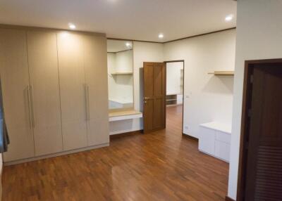 Spacious bedroom with wooden flooring, ample wardrobe space, and a built-in desk