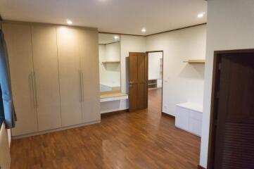 Spacious bedroom with wooden flooring, ample wardrobe space, and a built-in desk