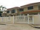 Modern two-story house with ornate white fence