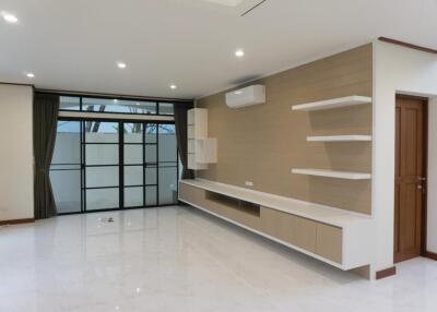 Spacious living room with large windows and built-in shelving