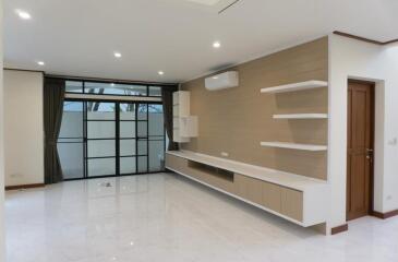 Spacious living room with large windows and built-in shelving