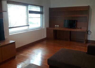 Living room with wooden furniture and large window