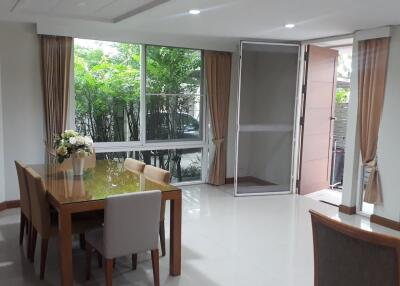 Dining area with table and chairs, large window and door leading outside