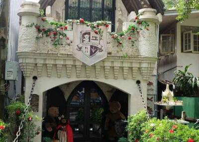 Front view of a decorative house with flowered balcony and plush bears