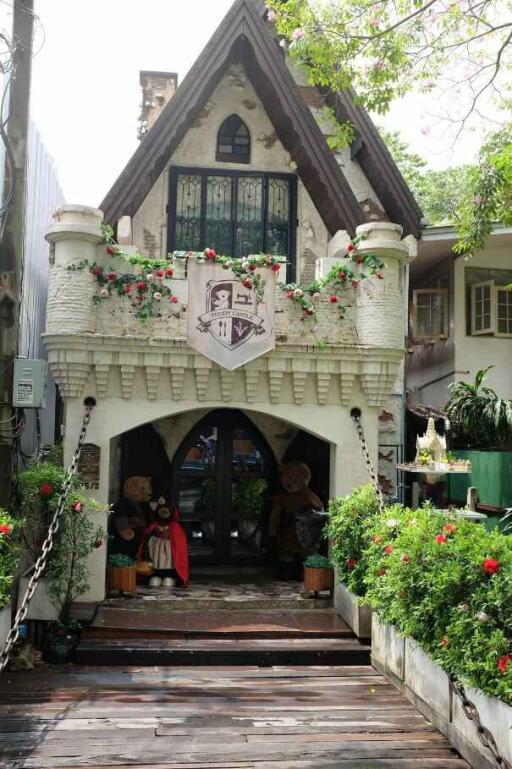 Front view of a decorative house with flowered balcony and plush bears