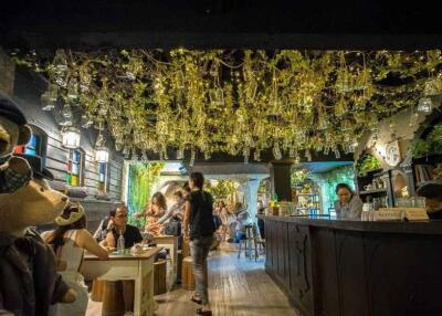 Cozy restaurant interior with hanging lights and patrons