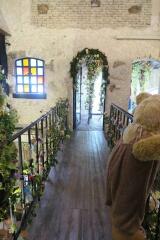 Arched hallway with wooden flooring and decorated with plants