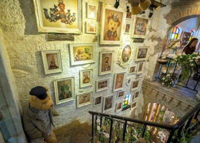 Decorated stairwell with framed artwork and stuffed animals