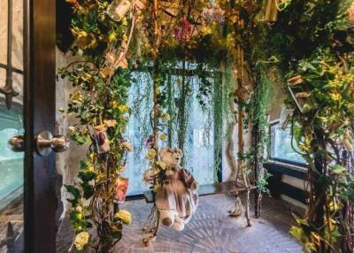 Enchanted garden-themed room with hanging flowers and teddy bear