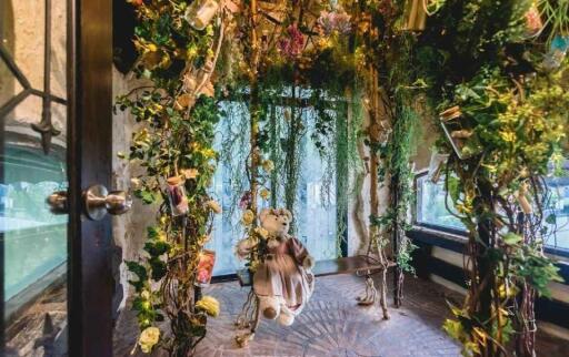 Enchanted garden-themed room with hanging flowers and teddy bear