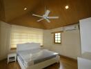 Spacious bedroom with wooden ceiling and fan