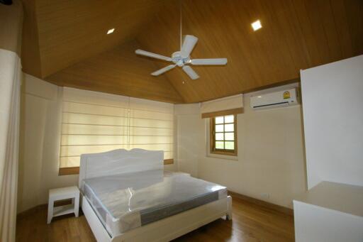 Spacious bedroom with wooden ceiling and fan