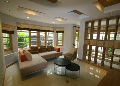 Modern living room with unique ceiling design and large windows.