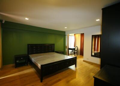 Spacious bedroom with a large bed and wooden flooring